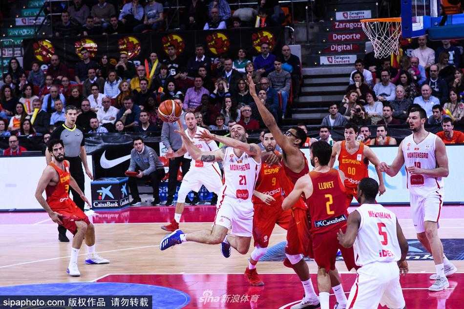西班牙队后卫在严密防守下强行突破，他犀利的眼神直视篮筐，黑山队两名球员的包夹也无法阻挡他前进的步伐。