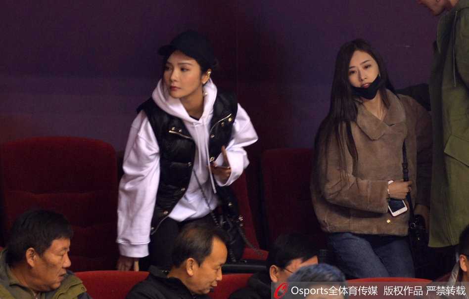 比赛暂停间隙，睢冉妻子侧身与丁彦雨航女友交流，眼神中透露出对场上局势的关切和对彼此的信任。