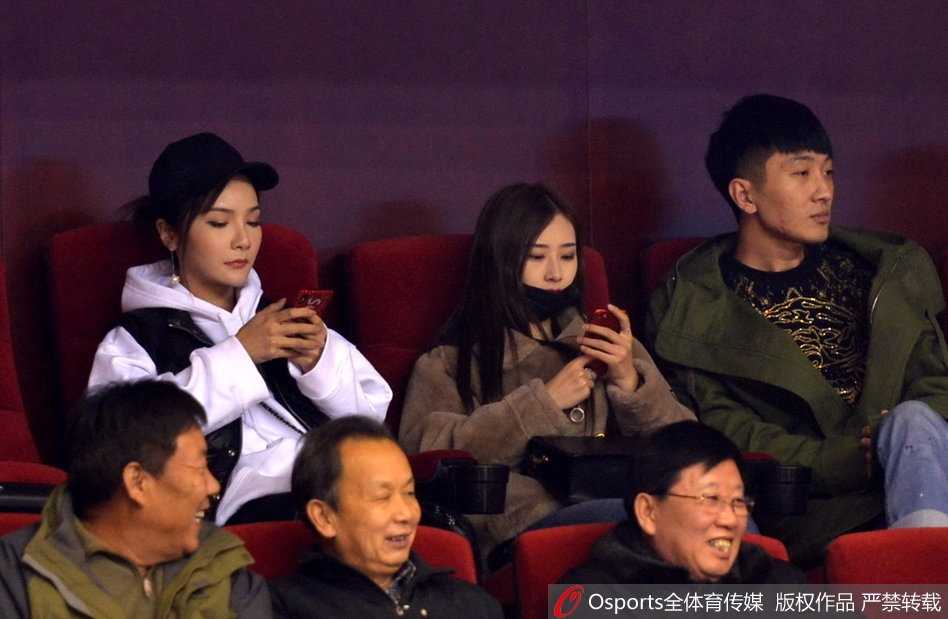 睢冉的爱妻与丁彦雨航的女友在看台上并肩而坐，两人的目光紧紧追随着赛场上的身影，神情专注而温柔。