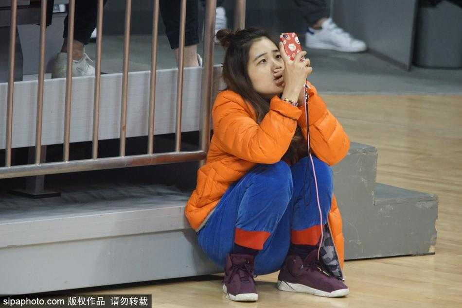 赛场边的别样风景线:记录WCBA的瞬间闪光 这位美女观众在人群中微微侧头,嘴角带着一丝若有若无的微笑,仿佛是看到了场上某个有趣的回合,这种自然的瞬间流露,比刻意摆拍更显动人。