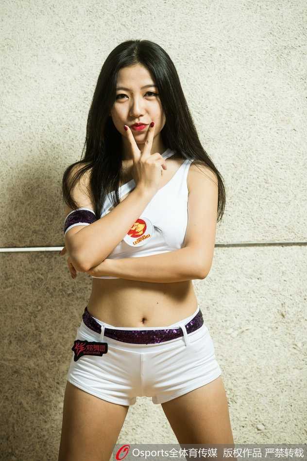 赛场边的热血舞者:CBA啦啦队的燃情新篇章 队员们背对镜头面向球场,整齐地高举手臂指向远方,仿佛在引领全场球迷为即将上场的球员呐喊助威。