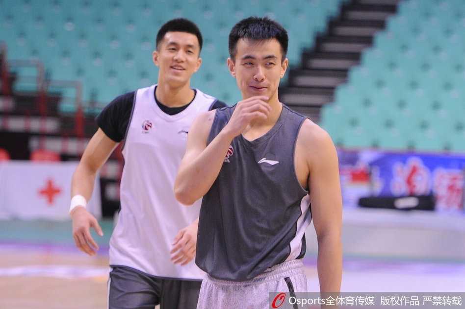 训练结束后，赵继伟在场边拉伸放松，郭艾伦则在一旁认真聆听教练的战术指导