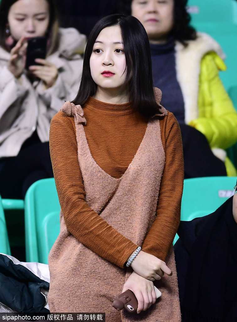 孙婉晴手持一张特制的圆形加油卡，上面印着辽宁队的标志，她将卡片轻轻放在面前，脸上洋溢着温柔的微笑，仿佛在用最温暖的方式为场上的球员传递力量。