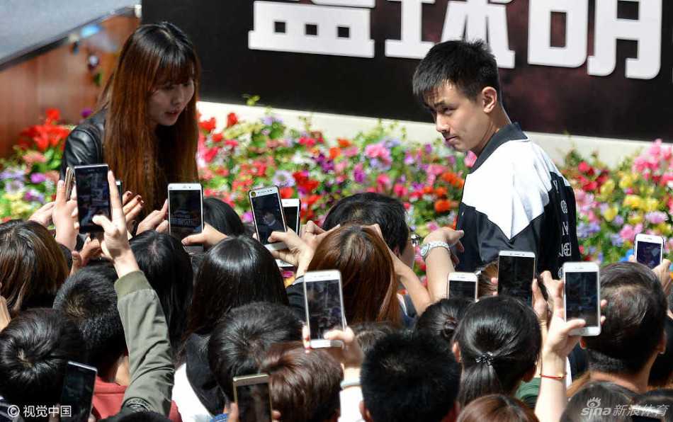 在签名合影环节，赵继伟低头为一名小球迷在篮球上签名，他神情专注，长睫毛在眼睑投下淡淡阴影，周围是无数伸过来的手机和期待的眼神，将这位CBA人气偶像的亲和力展现得淋漓尽致。