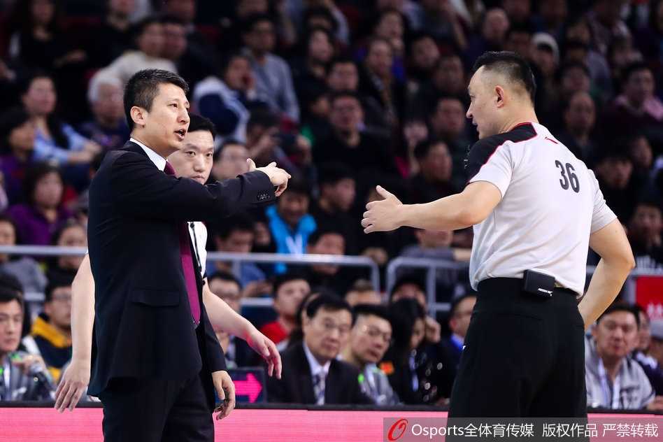 面对裁判的判罚，郭士强情绪激动地指着场地另一侧，仿佛在重现刚才的犯规过程。他的身体微微前倾，眼神中满是质问与不甘，即使助理教练试图上前劝阻，也无法让他停下申诉。这一刻，他不仅是主教练，更是要为球员讨回公义的家长。