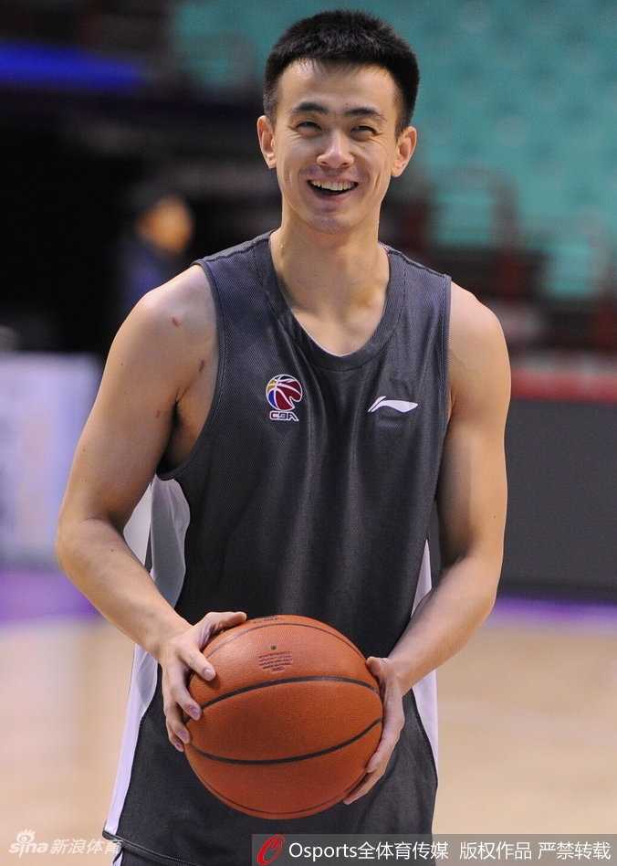 镜头拉近，一位穿着厚实棉服的年轻女球迷双手举着照片，眼睛里闪着期待的光。郭艾伦侧身站立，一边签名一边轻声询问她的名字，准备写下专属的祝福语，旁边的队友微笑着侧目，空气中流淌着家人般的亲切。