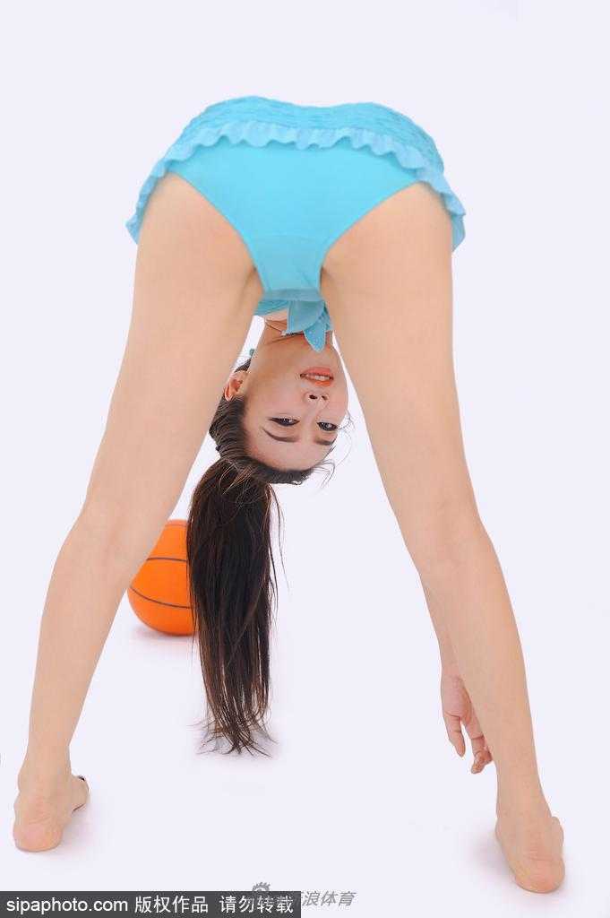 苏巍在篮球架下微微侧身，手托篮球，白皙肌肤在午后光晕中泛起象牙光泽，眼神专注而温柔，动静之间定格运动女神风范。