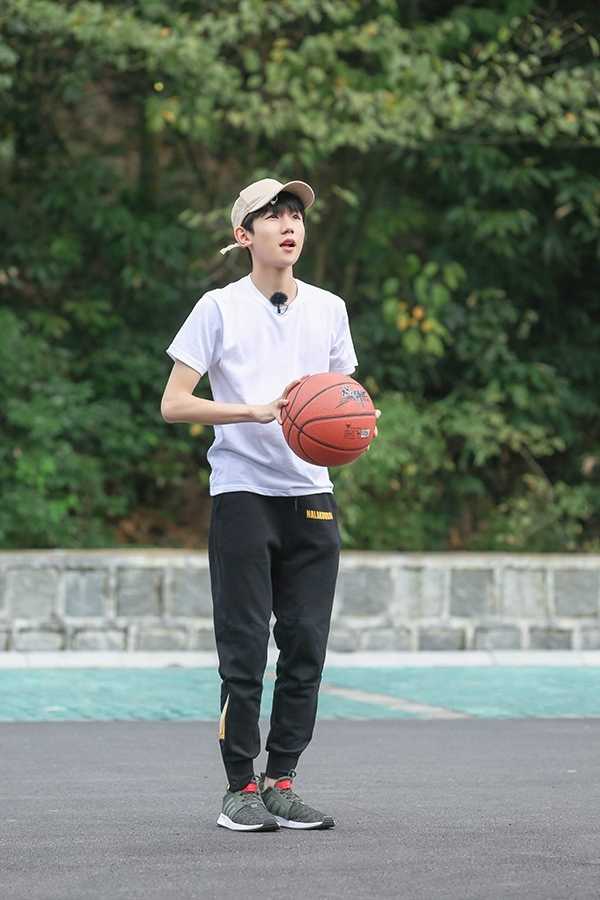 王源手持球拍蓄势待发，眼神锐利地注视着空中来球，棒球帽檐下的嘴角微微上扬，仿佛在享受这场与风的追逐游戏。