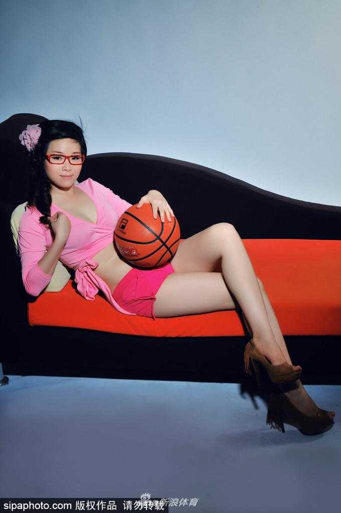 俯拍视角下，李怡与篮球亲密依偎，粉红色的衣装与棕色的篮球形成鲜明对比，凸显出她温柔中蕴含的爆发力，画面极具视觉冲击力。