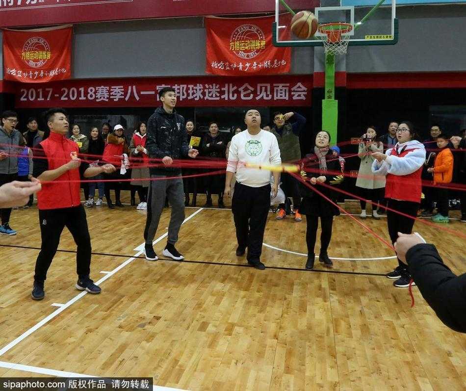 球馆内的互动环节，一名幸运的年轻球迷在场上防守雷蒙，他张开双臂，脸上洋溢着兴奋的笑容。