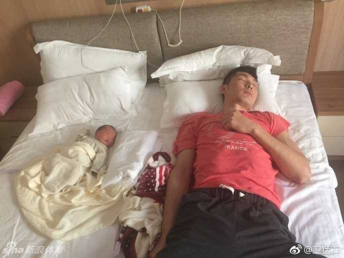 小宝宝躺在柔软的毯子上，小手微微张开，仿佛想要抓住什么。卫猛在一旁温柔地看着，这双在球场上抢篮板的大手，此刻只想给予孩子最温暖的守护。