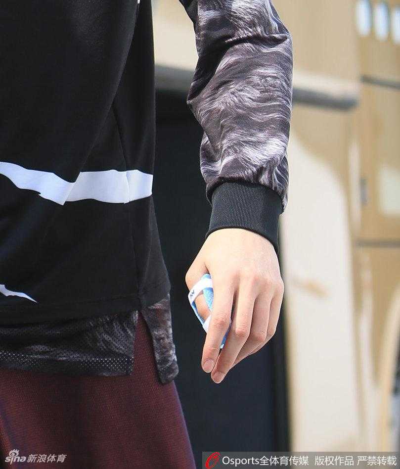 铁血飞虎,浴血逐梦——记新疆男篮总决赛前的最后一练 李根手提篮球鞋,大步流星地走在通往训练馆的通道上,眼神坚定,展现出总决赛关键先生的气场与自信。