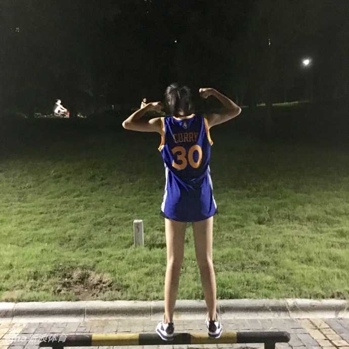 阳光洒在球馆木地板上，鲁西西ii身穿库里30号球衣回眸一笑，修长身影与篮筐构成一幅活力画卷