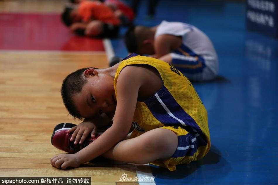 阜新篮球学校的训练馆内，一名小球员正独自加练，汗水湿透衣背，墙上“刻苦拼搏”的标语格外醒目。