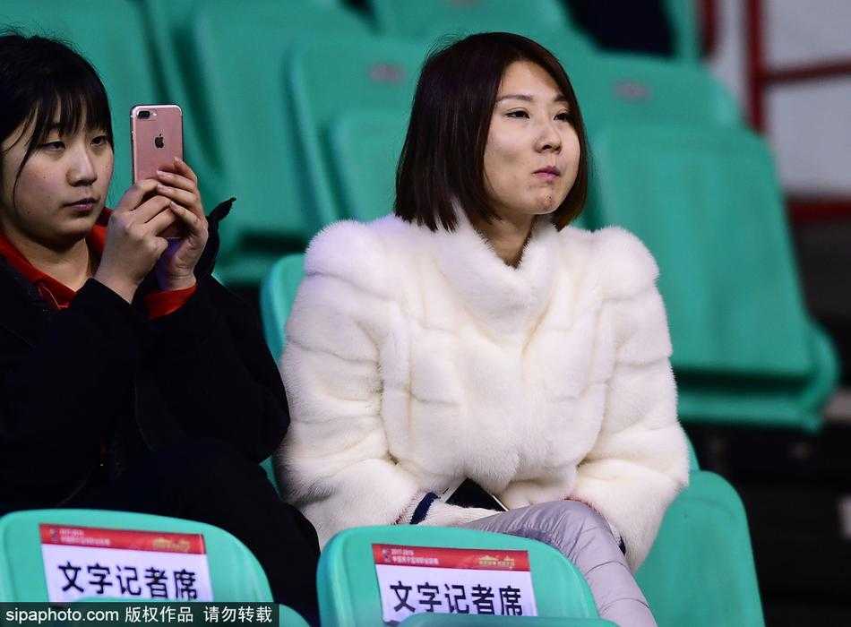 看台上，几位身穿黑色、深棕色貂皮大衣的球迷正聚精会神地观看比赛，他们厚重的皮草与周围穿着轻薄羽绒服的观众形成鲜明对比，脸上洋溢着对主队坚定的支持，仿佛这身行头就是他们最骄傲的“战袍”。