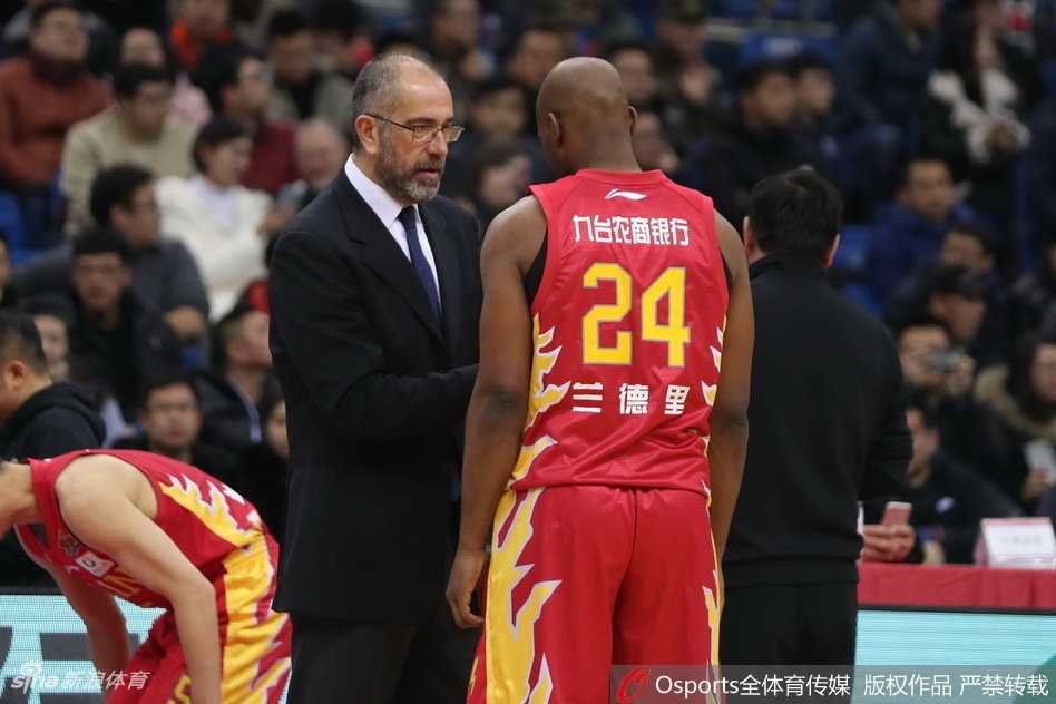 青岛队主帅巩晓彬在场边神情专注地指挥比赛，他的手势坚定，向场上队员传递着战术指令。