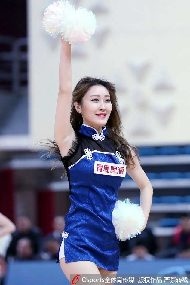 身穿亮黄色动感套装的长发篮球宝贝，在青岛主场看台前转身回眸，高抬腿的动作展现出优美的身体曲线和满满的青春活力