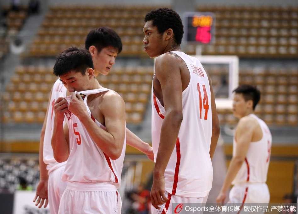 面对日本队归化球员布朗的强硬防守，胡金秋没有丝毫畏惧，他弯下腰，眼神坚定地运球试图突破，展现了中国内线的硬气。