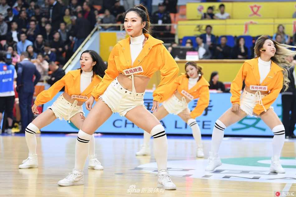 广厦啦啦宝贝们在赛场中央摆出活力开场造型，她们笑容灿烂，双手高举，仿佛在用青春的火焰瞬间点燃了整个球馆的热情。
