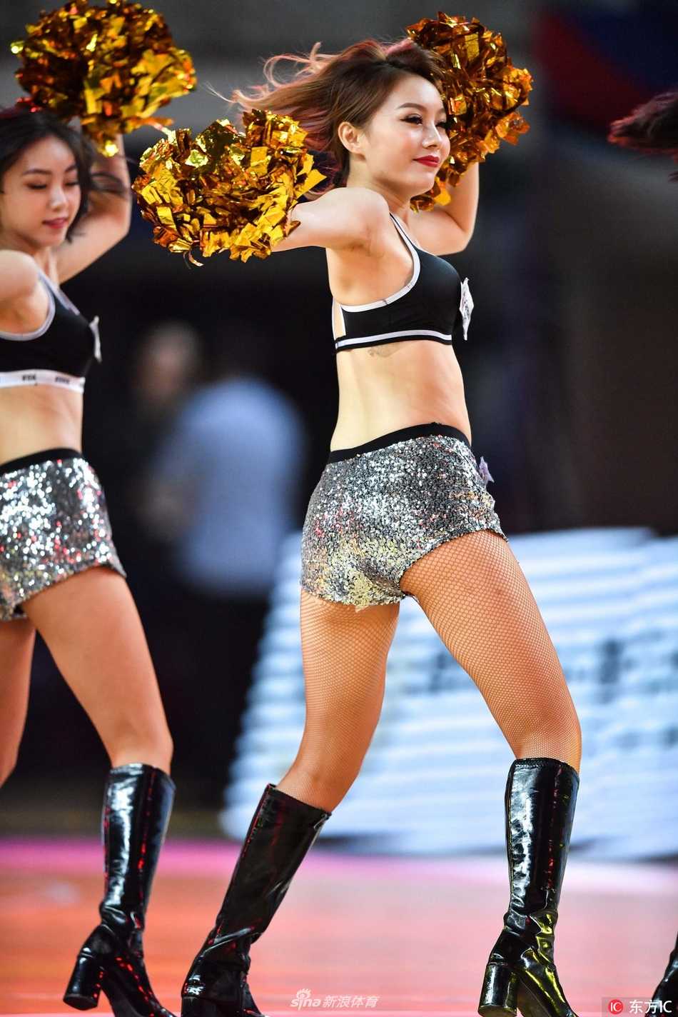 两位篮球宝贝背对背站立，侧身回眸看向镜头，一个俏皮地眨着眼睛，另一个则露出温婉的浅笑，展现出中国女孩灵动多变的独特魅力。