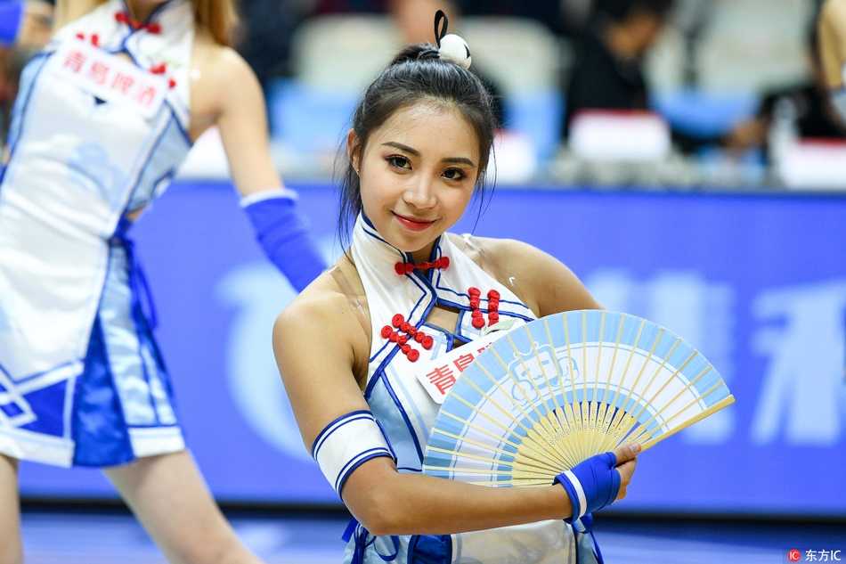 聚光灯下，一位笑容灿烂的啦啦队员正展臂起舞，灵动的身姿与飞扬的发丝完美结合，将现场激情四溢的青春活力淋漓尽致地展现给看台上的每一位球迷。