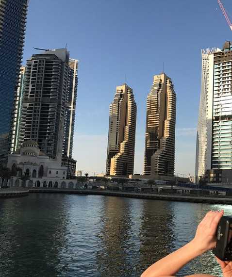 黄昏时分，亚当斯站在海边，远处夕阳染红天边，他张开双臂拥抱海风，享受这美妙的度假时光。