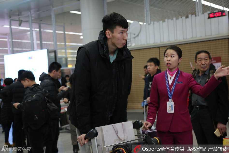 内线支柱周琦面带微笑走出机场通道，高大的身影在人群中格外醒目，他正向热情的接机球迷挥手致意。