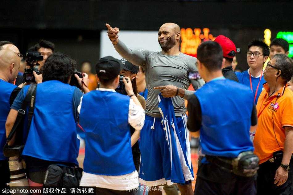 文斯·卡特持球突破，尽管已年届四十，但他的动作依然舒展飘逸，面对中国队的防守，他眼神坚定，随时准备起飞，将昔日的扣篮风采带到了香港的赛场。