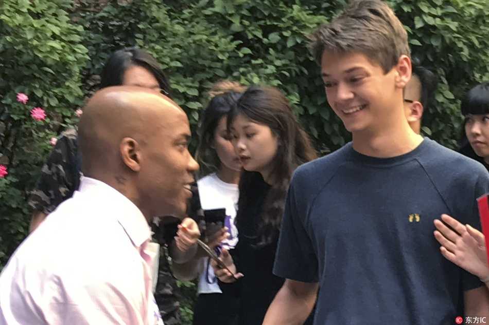 马布里在纽约大学教室内与学生们亲切互动，他面带微笑，专注地听着学生提问，周围的学生们聚精会神，气氛融洽。