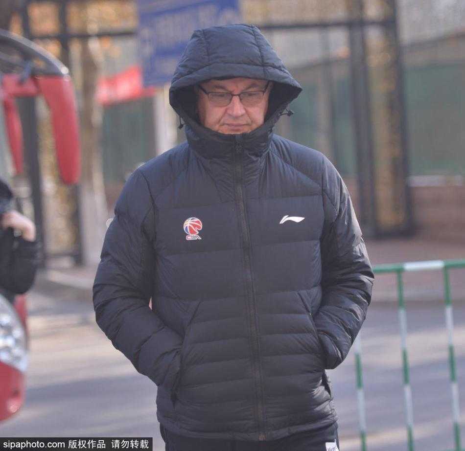 身穿蓝色训练服的易建联在山东高速球馆训练中持球，目光坚定，准备进行投篮练习。