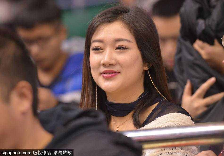 即使是低头沉思的瞬间，也构成了一幅动人的画面。她微微垂眸，手里似乎拿着什么，专注在自己的小世界里，周围的一切喧嚣仿佛都与她无关，这份独特的静谧之美，让人忍不住多看几眼。