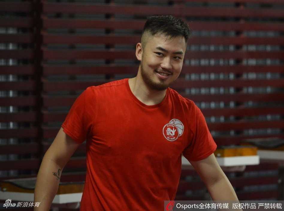 山东男篮全队围成圆圈，助教在圈中心大声布置战术，队员们手搭在一起齐声高呼加油