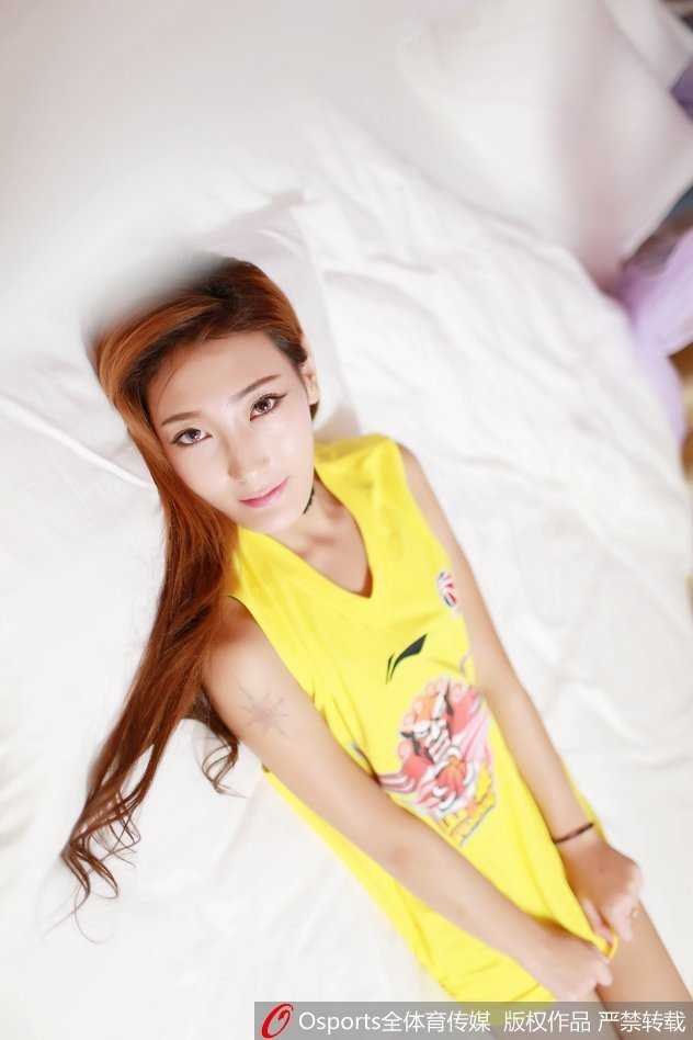 身着亮丽演出服的篮球宝贝，在后台休憩瞬间流露出不经意的温柔，一抹浅笑与身后的喧嚣形成对比，尽显动静皆宜的独特魅力。