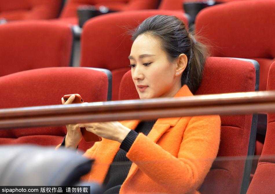 一位美女球迷正用手机记录下赛场上的精彩瞬间，她不仅是观众，也是这场篮球盛宴的传播者，希望将喜悦分享给更多人。