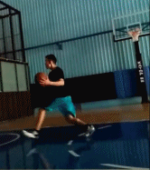 一名球员利用背后运球衔接欧洲步，球在身后灵动地弹跳，脚步也随之舞动，轻巧地穿过两名防守者的合围。