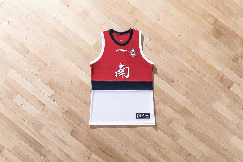 身披南区全明星专属热身T恤的孟铎在场边蓄势待发，红白的配色映衬着他自信的笑容，这件装备注定要在聚光灯下见证南区的荣耀时刻。